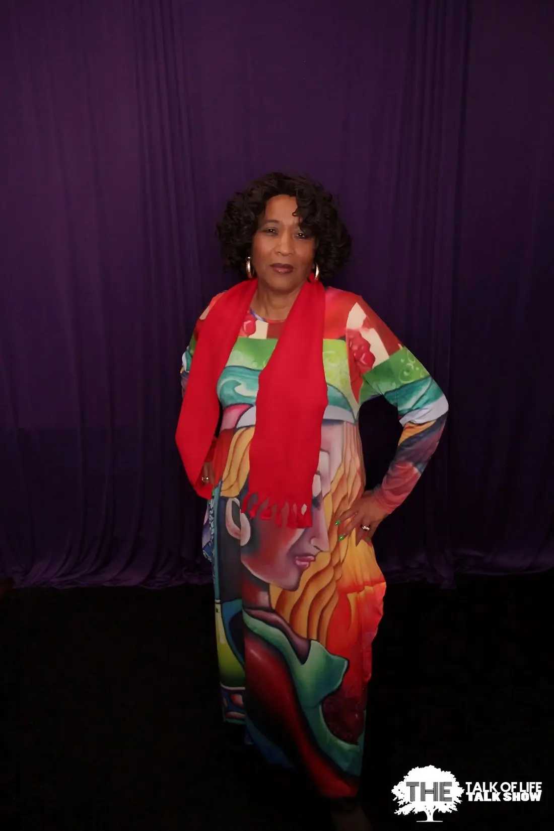 Elma in a colorful dress on the talk show set